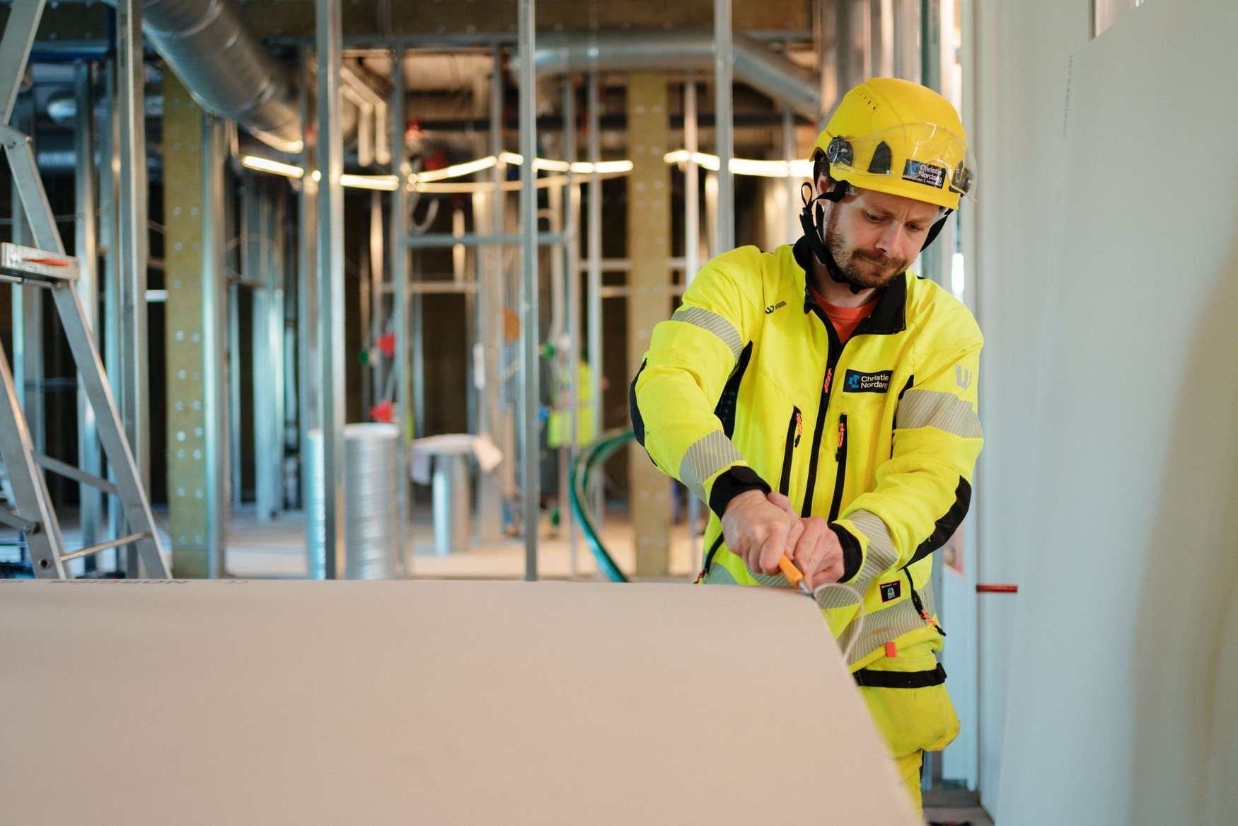 Christie Nordang worker cutting plasterboard indoors