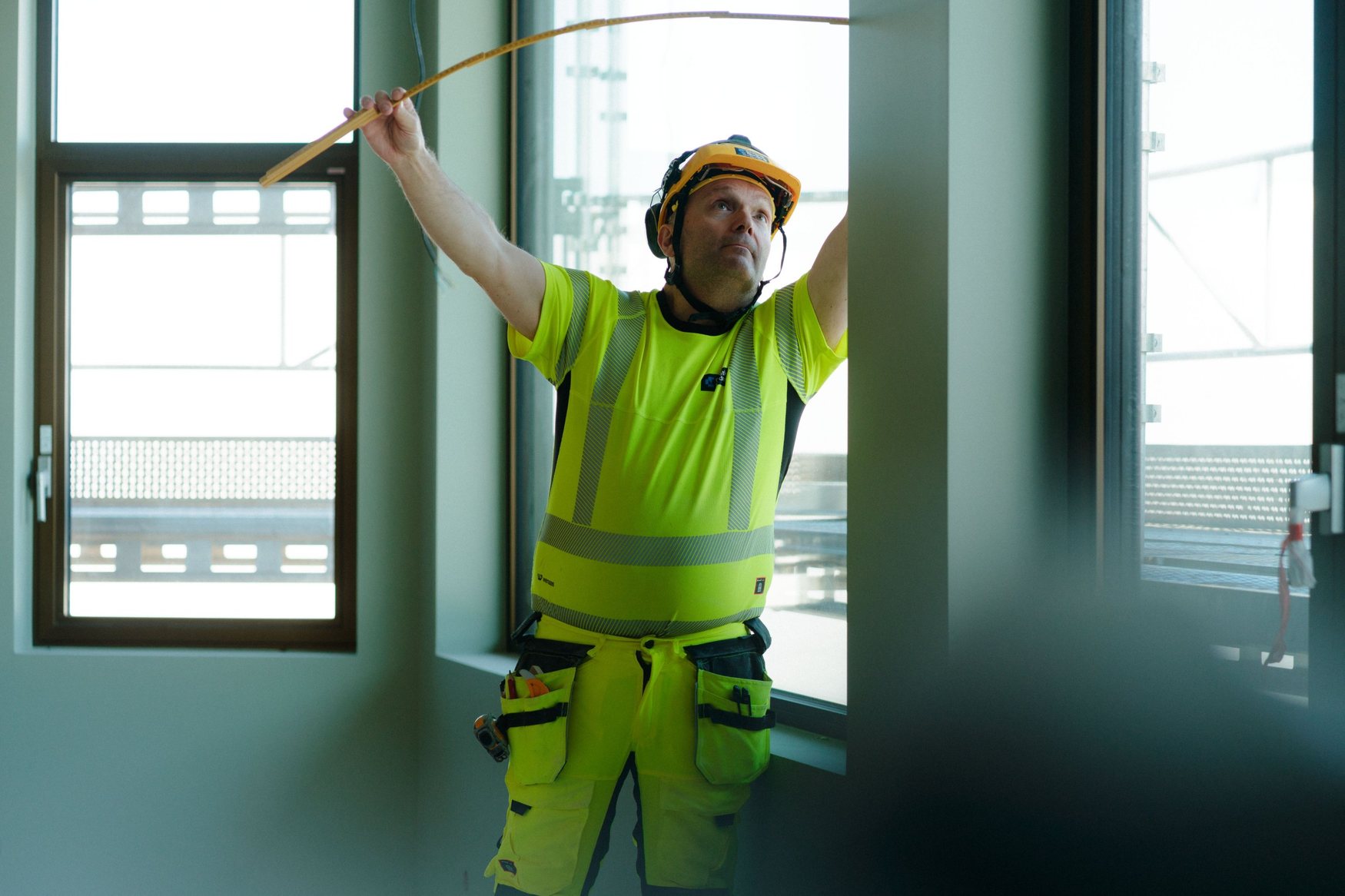 Christie Nordang carpenter measuring a window opening