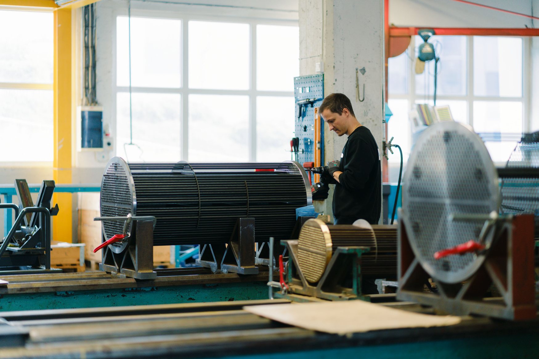 Hydroniq employee assembling a heat exchanger tube bundle in the workshop