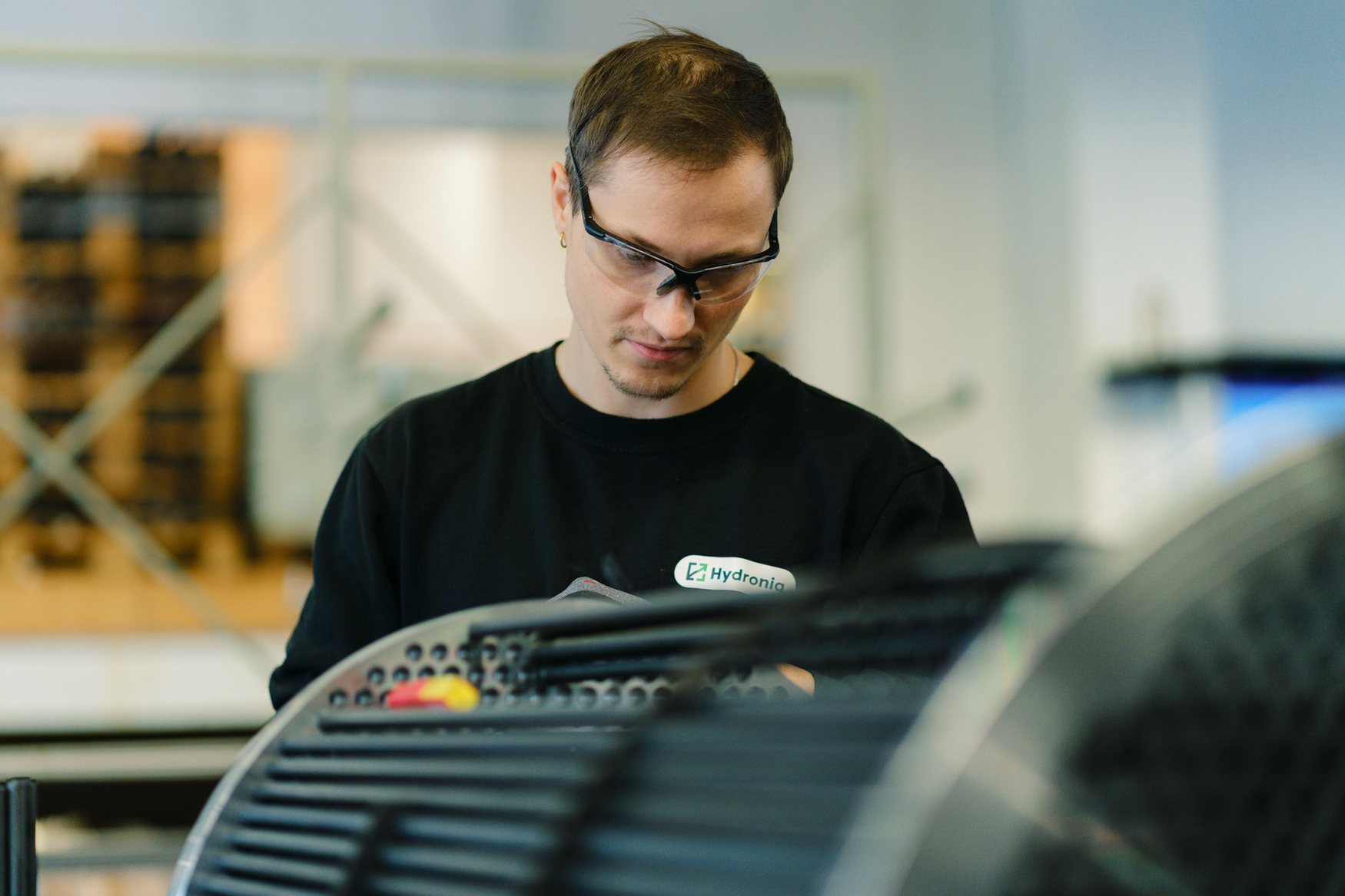 Hydroniq employee in safety glasses working on a tube bundle