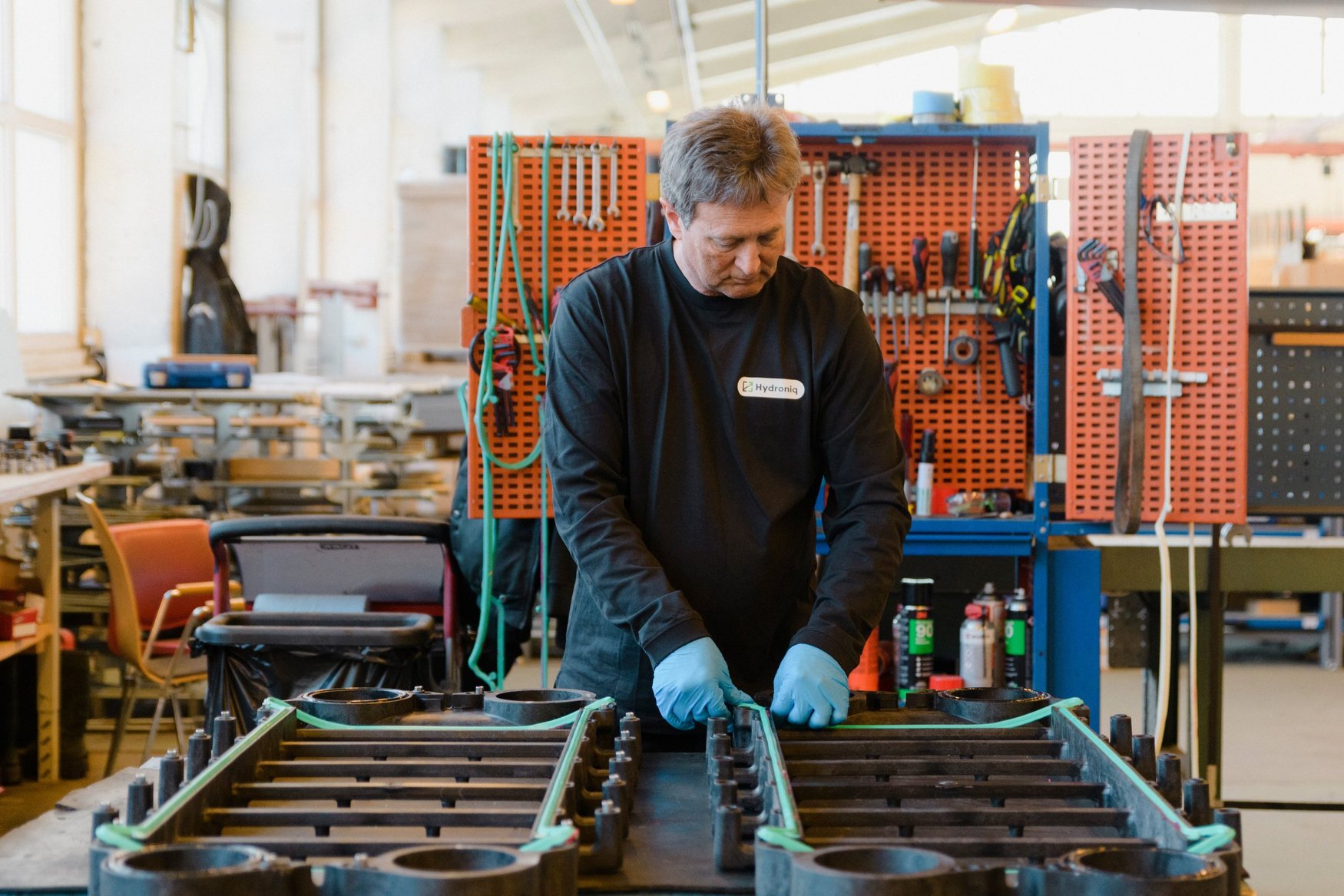 Hydroniq employee fitting gaskets on plate heat exchanger plates