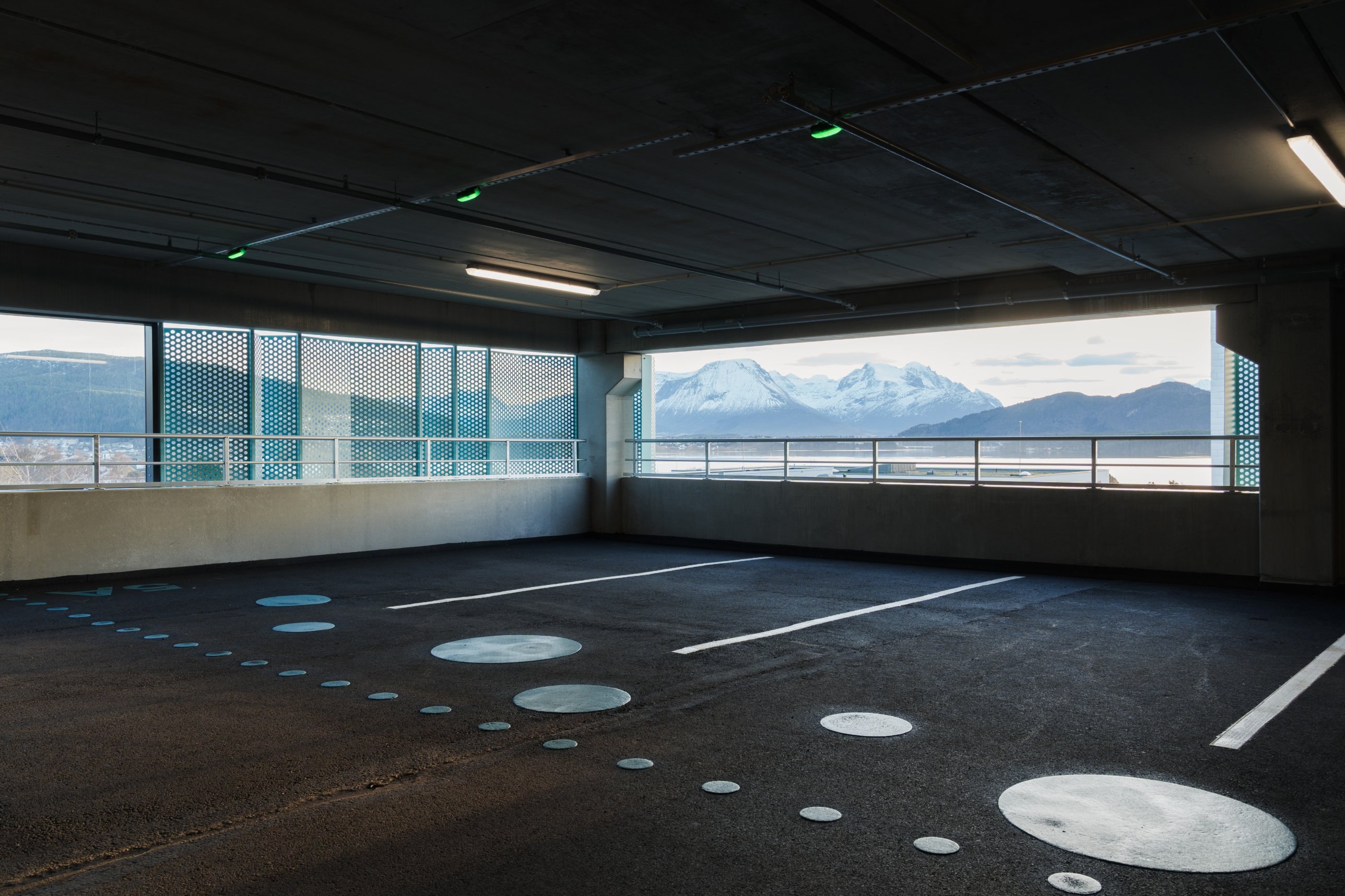Parking deck with dot markings and view of snow-capped mountains