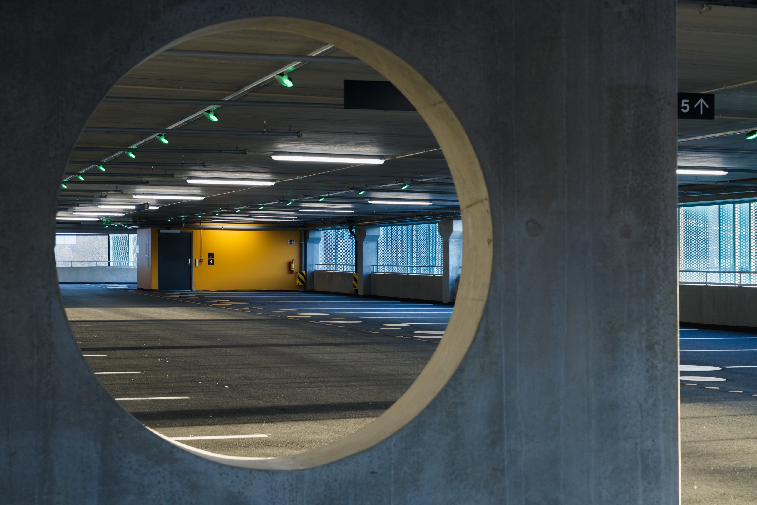 View through a circular concrete opening to a parking level